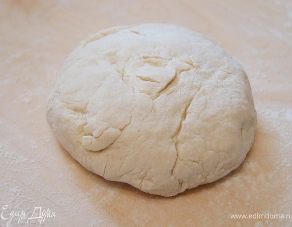Переложить тесто на стол и вымешивать до тех пор, пока оно не перестанет прилипать к не присыпанной мукой поверхности. С силой отбить тесто об стол-стукнуть собрать в шар, снова стукнуть. Повторять 6-8 мин. Завернуть тесто в пленку и оставить 15 мин в теплом месте.