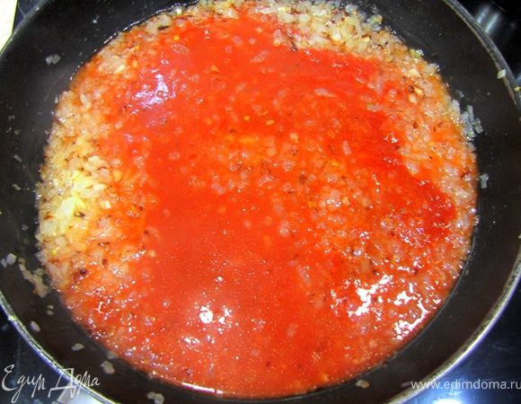 В разогретой сковороде жарьте лук на маленьком огне в течение 10 минут, часто помешивая, чтобы лук не стал сильно карамелизовываться, а только тушился. Лук должен стать мягким.
Залейте в лук разведенную томатную пасту, добавьте еще стакан кипятка и тушите минут 5. Не забудьте посолить и поперчить, предварительно попробовав на вкус.