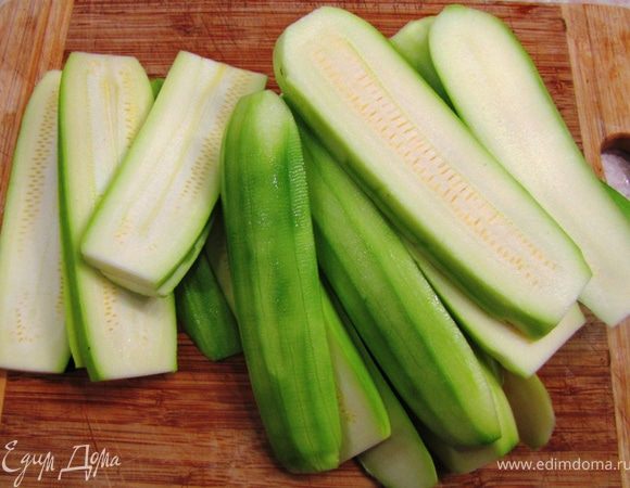 Положите к мясу и запекайте без крышки 10 минут.
Почистите баклажаны и кабачки, порежьте их на толстые ломти.