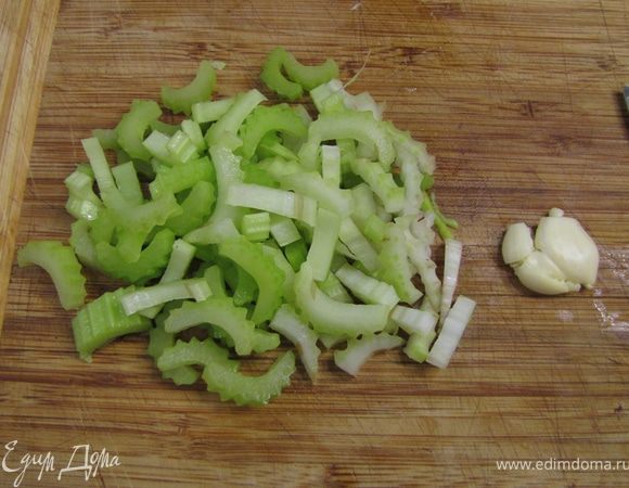 Ударьте плоской стороной ножа по зубчику чеснока так, чтобы кожица лопнула. Отрежьте попку и кожицу будет легко снять. Нарежьте соломкой сельдерей поперек стебля.
