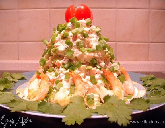 Выложить на тарелку в виде конуса, посыпать зеленым луком. Должно получиться похожим на елочку. Из помидорки черри сделать звезду.  Выложить целые креветки как будто новогодние подарочки. 