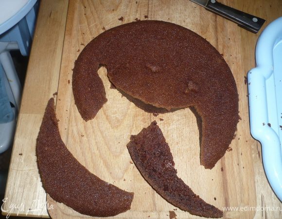 Выкроить дракона,  каждую часть разрезать на 3 коржа, каждый слой/корж дракона промазать кремом. Из остатков бисквита сформировать затылок, спинку и лапки дракона. Отправить в холодильни на 4 часа.