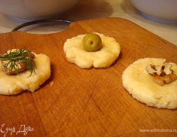 Скатать шарики небольшие- 15 шт. Из них сделать лепешки.
В центр каждой лепешки положить- оливки, на другие лепешки- шпроты с укропом, на третьи лепешки- грецкие орехи (как показано на фото).
