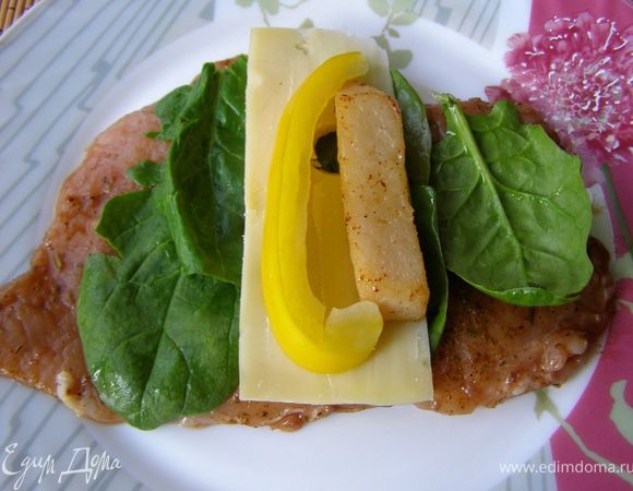 На подготовленное филе разложить по 4-5 листиков шпината, на расстоянии 3 см от края положить пластик сыра, а на него полоски перца и груши. 