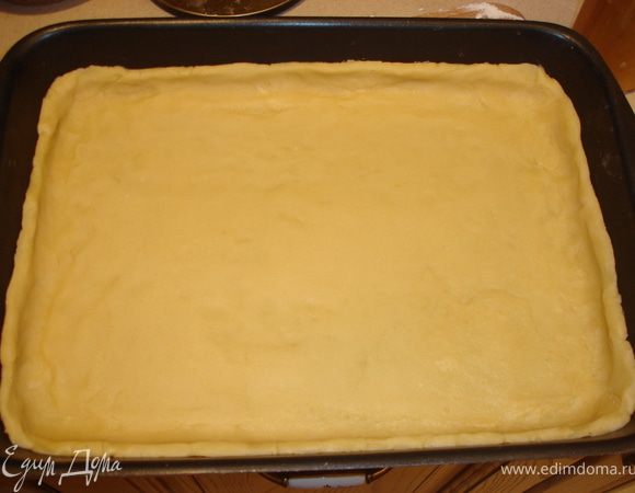 Тесто расказать толщиной 1 см, выложить в форму для выпечки с бортиками. Выложить лимоны, разровнять, разбросать изюм.