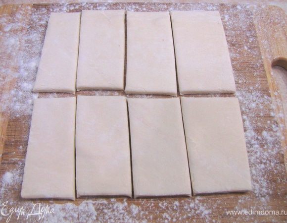 Разморозьте 2 пласта теста, не забыв посыпать муку под них. Положите на разделочную доску и разрежьте на 8 частей каждый пласт. Я разрезал ножом для пиццы.