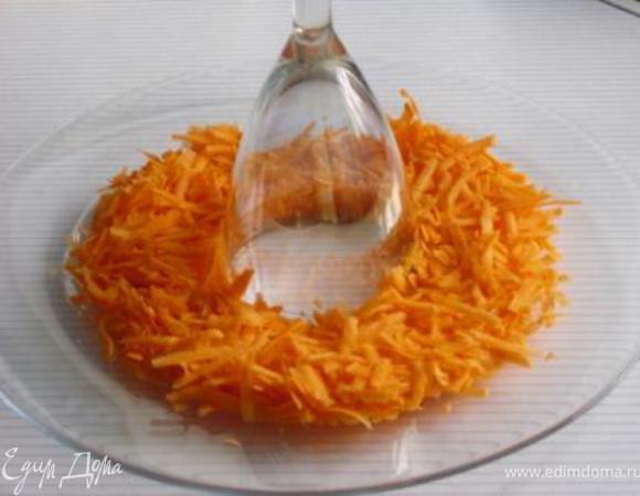 Натереть на крупной терке морковь и выложить её  вокруг стакана (или фужера:), предварительно установленного в центре блюда.
