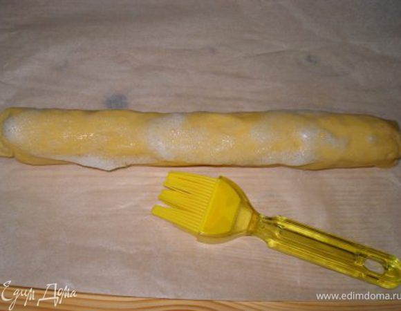 Взбить белок в хорошую пену, смазать ею тесто со всех сторон.