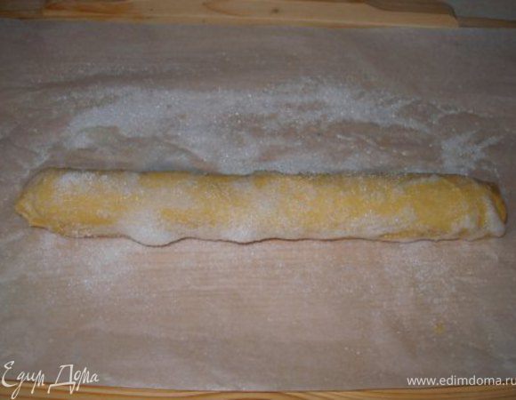 По пергаменту рассыпать сахар и прокачать по нему тесто, чтобы сахар везде облепил его.