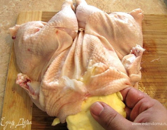 В принципе такой способ разделывания курицы "прячет" грудку посередине и она будет защищена от лишнего жара, но для лучшей защиты от пересушивания мы положем сливочное масло на грудку под кожу. Отделите кожу от грудки. Кожа к грудке практически не прикреплена, поэтому вы легко это сделаете, просунув пальцы под кожу. Разомните масло и придайте ей форму, аналогичную грудке. Засуньте масло под кожу и разровняйте его. Убедитесь, что масло не съедет в сторону.