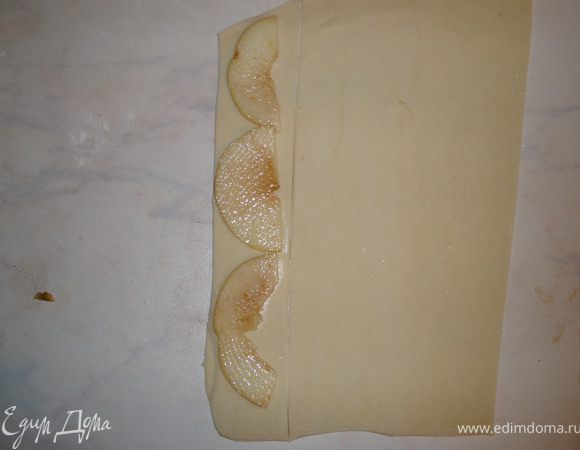 На полоски выкладываем яблоки, примерно по три кусочка, присыпаем сахаром. 