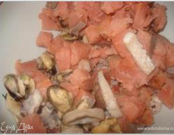 Выложить сваренные морепродукты в чашку. Горбушу или кету нарезать кубиками и добавить в чашку с морепродуктами.