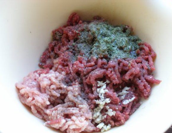 В фарш добавить чеснок, петрушку, соль, перец. Хорошо перемешать.