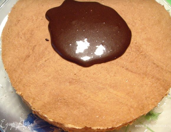 Для покрытия верхнего коржа приготовить шоколадную глазурь. Смешать все составляющие и прогреть на водяной бане.  Остудить и распределить по поверхности торта.