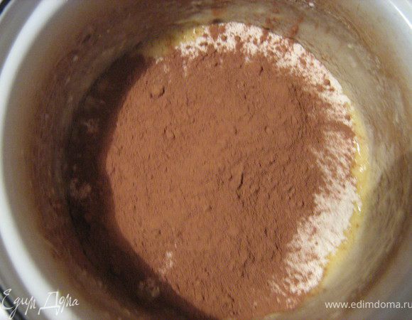 В масляную смесь просеиваем муку с какао и разрыхлителем.