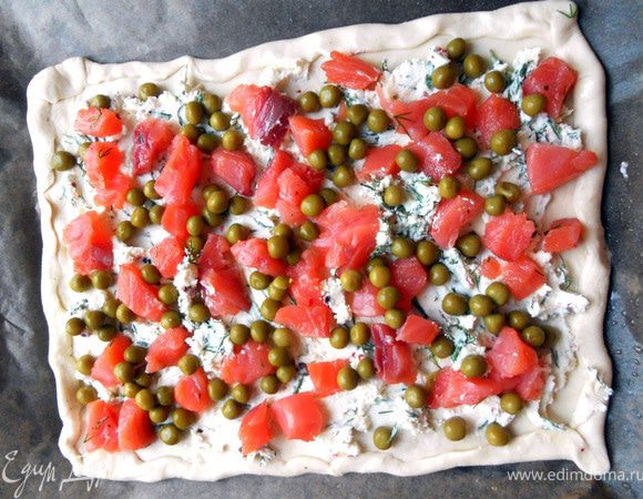 Поверх выложить рыбу и зеленый горошек (в идеале замороженный (предварительно разморозить), но у меня оказался только консервированный - и с ним, конечно, неплохо, но не столь душевно). Выпекать в предварительно разогретой духовке до готовности (15-20 минут). В горячем виде тесто будет казаться влажным, из-за маскарпоне, поэтому нужно дать остыть, после чего нарезать порционно и подавать. 