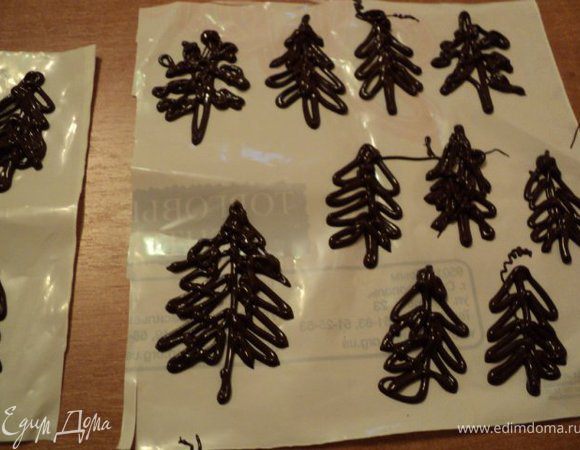 Подготовить украшение; шоколад поломать на кусочки, положить в пластиковый пакетик, растопить в микроволновке 1 мин, срезать уголок и нарисовать на пленке елочки. Поставить в холодильник.