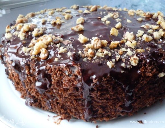 Бока торта украшаем бисквитной крошкой.Варим глазурь:смешать какао с сахаром и затем добавить к теплому молоку и хорошо размешиваем,ставим на небольшой огонь и помешивая венчиком варим до получения однородной и гладкой блестящей массы,затем добавляем измельченный шоколад и масло и быстро перемешиваем до растворения шоколада и масла.Убираем с плиты и добавляем коньяк,перемешиваем и даем остыть до теплого состояния.Глазурь равномерно распределяем с помощью ложки по поверхности торта и даем ей застыть.Затем торт украшаем орешками и убираем его в холодильник.Все!Приятного вам чаепития:)