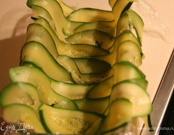 Форму для террина выстелить пищевой пленкой,ломтики цукини уложить поперек формы,лишние края загнуть наружу.