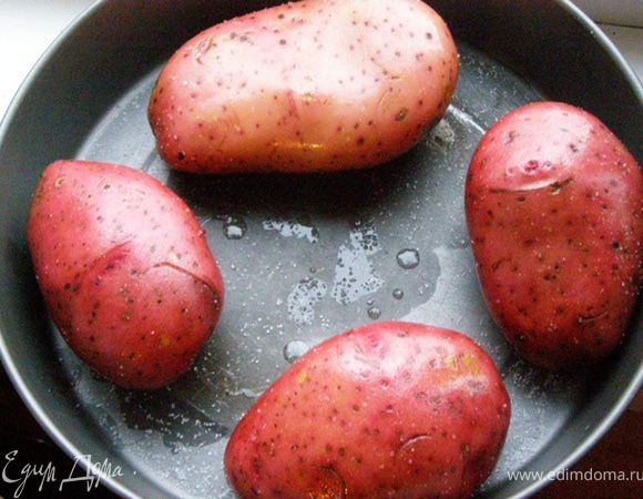 Картофель тщательно помоем со щеткой, высушим полотенцем. Проткнем кожуру картофеля в нескольких местах вилкой. Капнем на картофелины оливковым маслом и вотрем его в кожуру. После этого вотрем в кожуру соль. Картофель выложим в форму для запекания и будем запекать в предварительно разогретой духовке около двух часов.