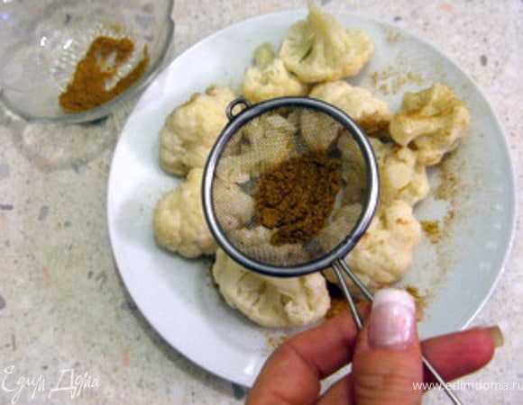 Отваренную капусту обсыпать смесью специй, используя для этого небольшое ситечко.