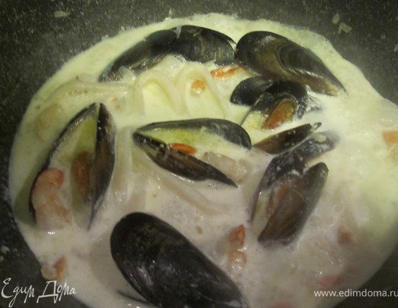 Добавить щепотку муки в морепродукты, залить сливки, посолить и поперчить. Тушить 5 минут.