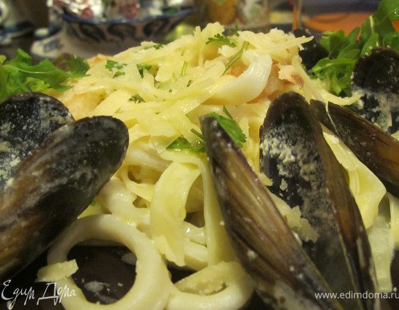 За 2 минуты до готовности слить пасту и добавить ее к морепродуктам.Тщательно перемешать.Подавать пасту сразу же щедро присыпав пармезаном и свежемолотым черным перцем.В тарелку выложить рукколу и сбрызнуть оливковым маслом. приятного аппетита!