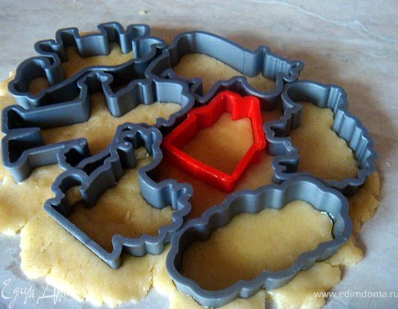 Духовку разогреть до 170--180 гр.ц. Противень выстелить пергаментом (совет: чтоб пергамент не елозил по противню-смочите противень водой и сверху положите пергамент. При запекании нескольких партий печенья используйте один и тот же пергамент).
Стол присыпать мукой- тесто раскатать примерно 0,5 см. толщиной. Вырезать фигурки и разлогить их по пераменту.