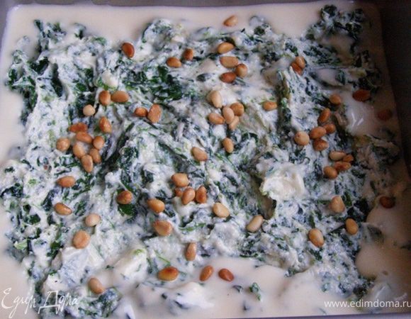 В форму нальем немного соуса, выложим 1/3 шпинатно-сырной смеси, присыпем кедровыми орешками