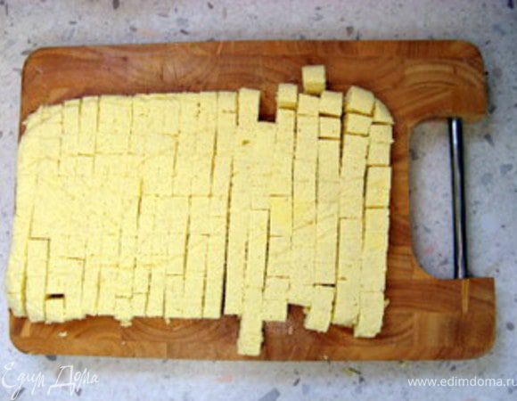 Через час достать из формы  запеканку, перевернув её, отделить от бумаги и нарезать  на мелкие кубики.
Выложить кубики в супницу или тарелки и залить горячим бульоном. 
