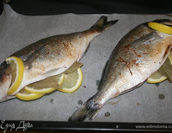 Очистить рыбу, натереть солью. Половину лимона порезать кружочками. Вложить внутрь каждой рыбы по 2 кружочка, за жабры половинку кружочка лимона. И по 2 лавровых листа. Натереть рыбок паприкой. Сделать Х-образные надрезы на внешней стороне.