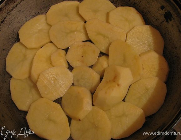 Картофель очищаем нарезаем кружечками и выкладываем на дно формы,смазанное маслом.