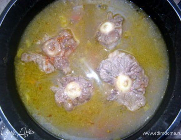 Затем влить 1300 мл воды и 500 мл вина. Добавить так же помидор, свежий без шкурки или консервированный.
Накрыть крышкой и дать супу закипеть. Когда суп закипит, приоткрыть крышку и варить 2 часа на слабом огне.
