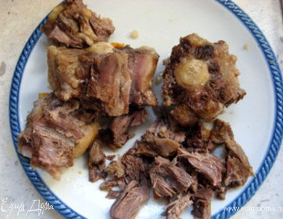 Через 2 часа достать готовый хвост из бульона и отделить мясо от костей.