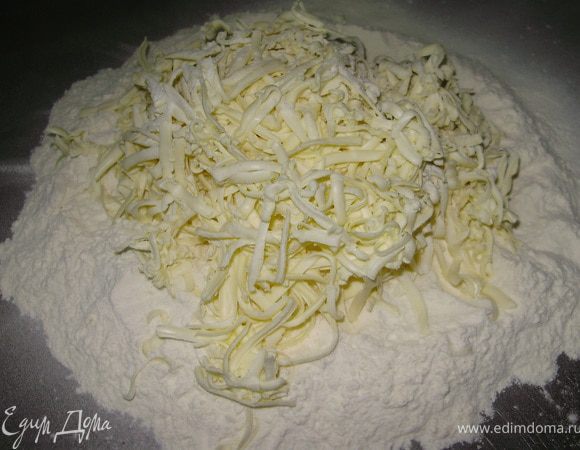 Просеять 480г муки на стол потереть на крупной тёрке охлаждённое масло. 