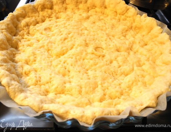 Достаем тесто из холодильника и распределяем по форме, застеленной бумагой для выпечки. Я рекомендую взять половину теста,  у меня получился достаточно толстый слой из всего количества. Оставшуюся половину можно заморозить. Наколоть поверхность вилкой и выпекать 10 минут в духовке, разогретой до 170 градусов. Вынимаем из духовки и слегка остужаем. Огонь в духовке уменьшаем до 150-155 градусов.