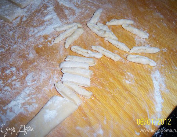 Тесто раскатать на пласт толщиной 1см., далее разрезать на полоски шириной 3см., а полоски нарезать на кусочки толщиной 1см., надавливая на кусочик двумя пальцами скручиваем по направлению к себе.
Не жалей те муки, чтоб галушки не прилипали друг к другу.