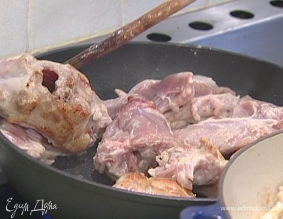 В глубокой сковороде, которую можно ставить в духовку, разогреть оливковое масло и обжаривать кусочки кролика до появления румяной корочки.