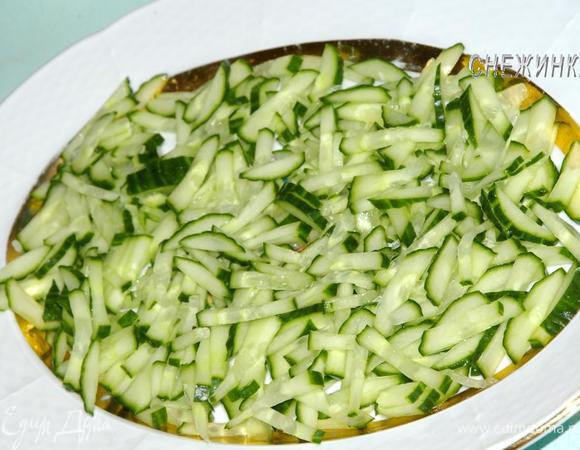 Порезать огурец соломкой и выложить на блюдо равномерно.