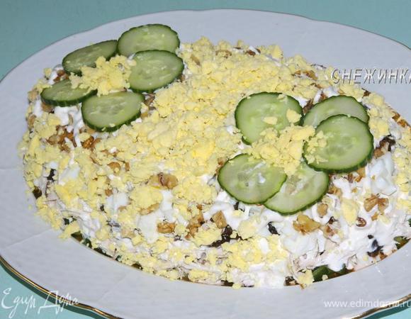 Для украшения огурец порезать тоненькими колечками. Выложить в виде лепестков цветочков, в центре которых – немного измельченного в руках желтка. Посыпать по бокам и оставшейся поверхности салата желтком.