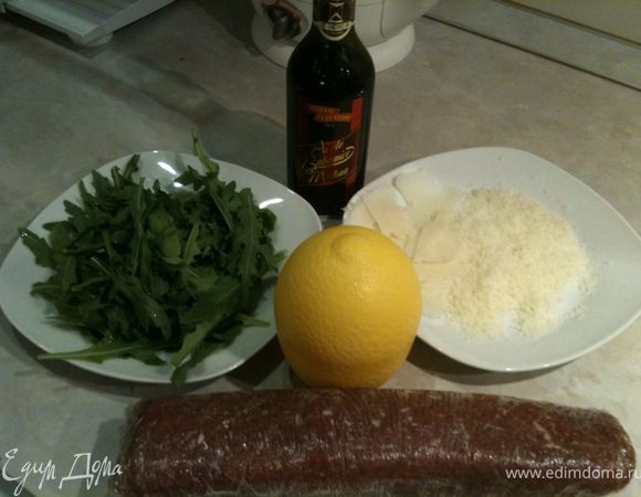 Перед подачей достать мясо из морозилки (примерно за 30 минут).
Рукколу промыть, удалить твердые стебельки и обсушить. 1/2 часть Пармезана натереть на терке, вторую нарезать слайсами с помощью овощечистки.