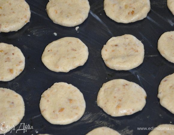 Скатать из теста шарики размером с грецкий орех и немного приплюснуть. Форму смазать маслом и выложить на неё печеньки.