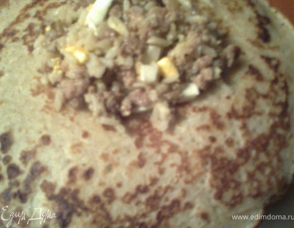 Выкладываем столовую ложку начинки на румяную сторону блинчика.