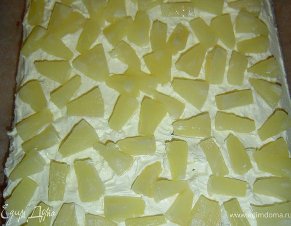 а на него выкладываем нарезанные небольшими дольками консервированные ананасы. Накрываем вторым коржом.