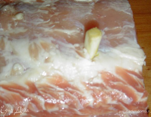 Делаем небольшие надрезы по всему периметру мяса и шпигуем чесноком.