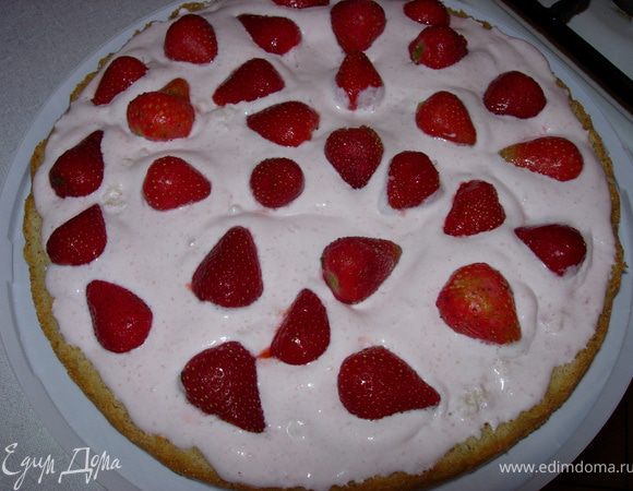 Теперь (лучше в разъемной форме, но я делала и без нее) на один пласт бисквита выкладываем половину крема и порезанную на кусочки клубнику 