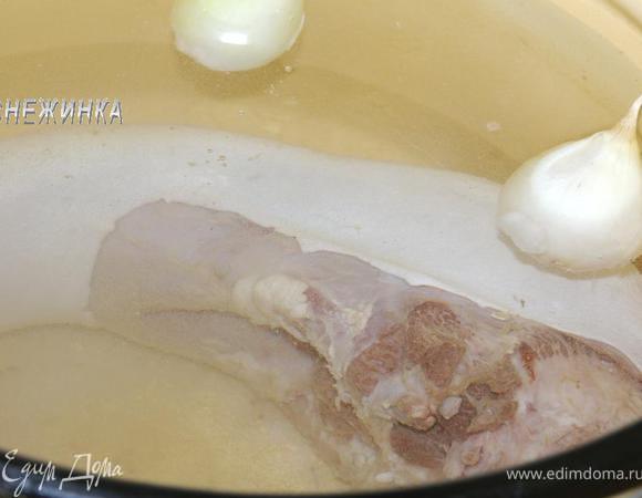 Язык помойте, отправьте вариться в большой кастрюле. Влейте воду так, чтобы она немного покрывала язык. Когда вода закипит, слейте воду, язык промойте, залейте холодной водой. У меня кастрюля объемом 6 л. Я налила около 5 л воды. Отварите язык, подсолив воду (я сразу добавила 1,5 ст. л.) и положив очищенные луковицы. По мере образования снимайте пенку.