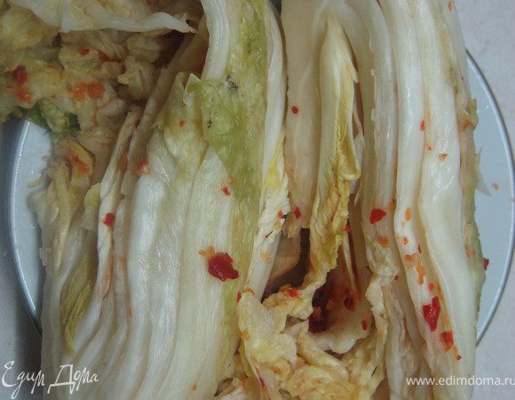 Всю обработанную капусту вновь уложите в емкость и поставьте под гнет. Капуста снова даст сок, в таком виде ее нужно выдержать около суток. После того как капуста постоит в тепле, она даст приятную кислинку. Можно подождать и дольше, если хочется больше кислоты. Затем капусту нужно поместить в холодное место. 