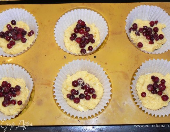 В формочки выложить кукурузное тесто,затем выложить  ягоду.