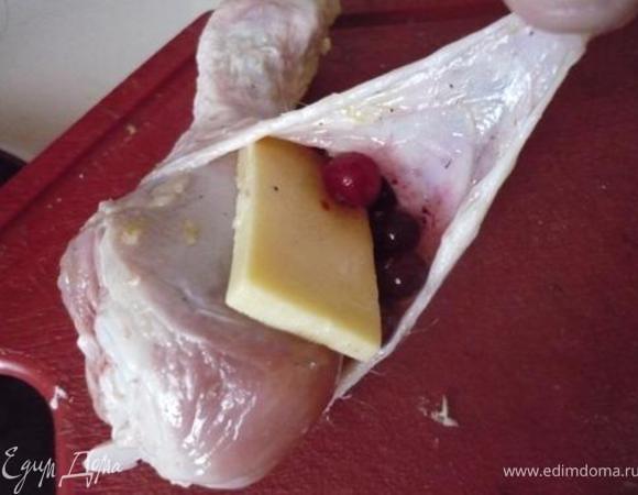 Вынуть голени из маринада, снять лишнюю жидкость салфеткой. У каждой голени немного оттянуть шкурку, сделав кармашек. В него положить кусочек сыра и зерна граната/клюкву.